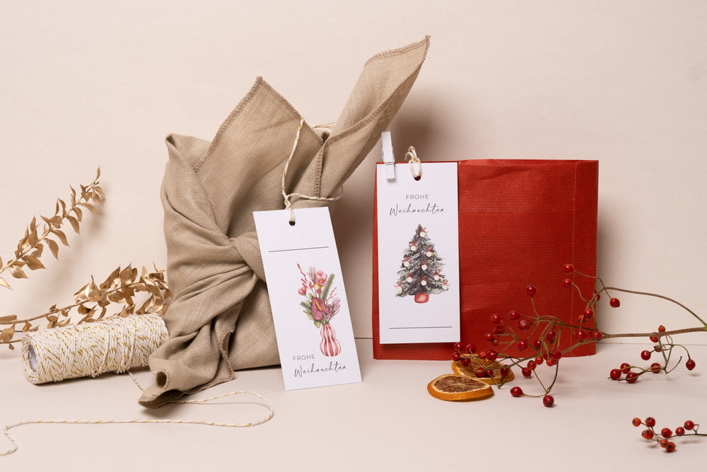 Geschenkanhänger mit Tannenbaum und Blumenstrauß an einem Weihnachtsgeschenk
