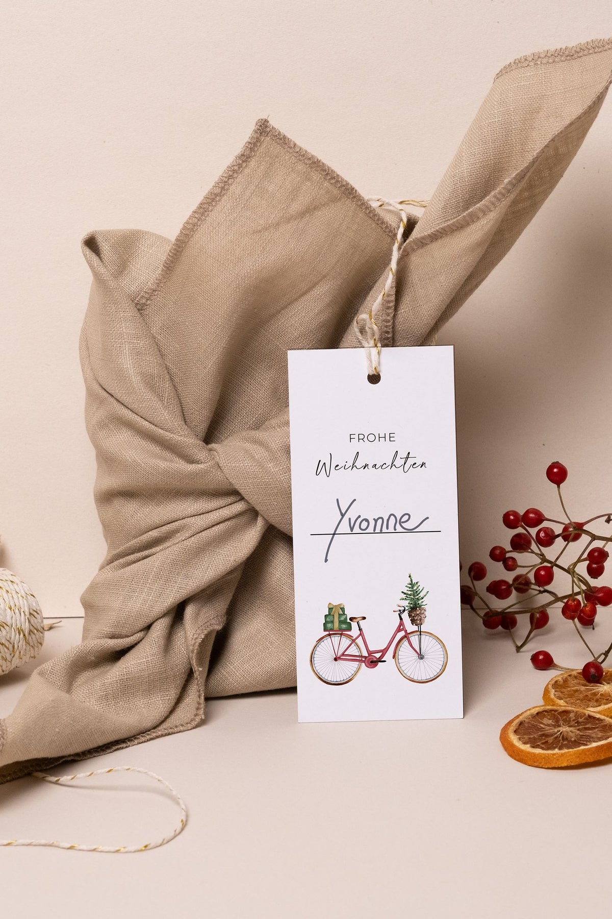 Weihnachtsgeschenk in Leinen verpackt mit Geschenkanhänger Frohe Weihnachten und Namen